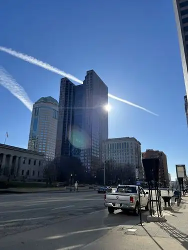 Sun-drenched skyscrapers reach for a stunning blue, contrail-filled sky.